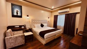 um quarto de hotel com uma cama e uma cadeira em Vintage inn by Pepe Hospitality em Bangalore