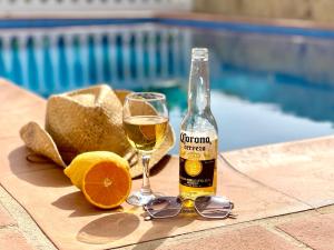 een fles champagne en glazen naast een zwembad bij Villa Nuria in Frigiliana
