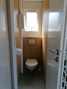 baño pequeño con aseo y ventana en SAFRED Mobile Home Portbail-sur-Mer en Portbail