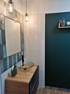ein Badezimmer mit einem Glaswaschbecken und einem Spiegel in der Unterkunft Apartament Szmaragdowy in Jelenia Góra