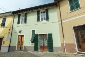 a building with green shuttered windows and doors at Albergo diffuso "Centoborghi" in Fivizzano