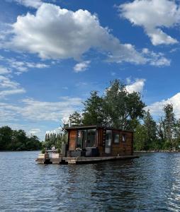 een klein huis op een schuit in het water bij Gemütliches Hausboot mit Kamin in Berlin in Berlijn