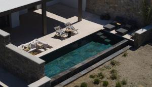 Draufsicht auf ein Schwimmbecken mit zwei Stühlen und einem Tisch in der Unterkunft Bonzoe Suites & Villas in Mykonos Stadt + 107 Fotos