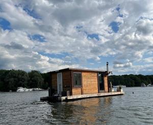a tiny house on a dock in a body of water at Gemütliches Hausboot mit Kamin in Berlin in Berlin
