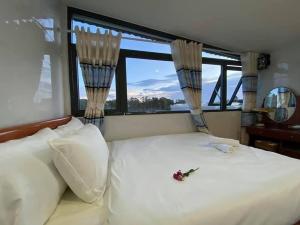 a bedroom with a white bed with a window at Thảo Lan Hotel in Da Thien
