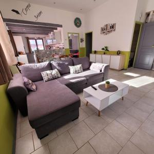 een woonkamer met een bank en een salontafel bij Appartement agréable et spacieux ensoleillé in Valros