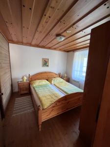 a bed in a room with a wooden ceiling at Apartments Roemerschlucht in Velden am Wörthersee