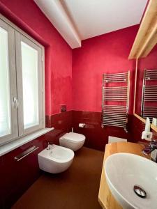 a red bathroom with two toilets and a sink at De Novo e d'Antico in Cori +33 photos