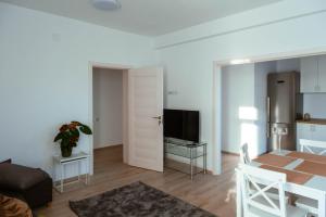 a living room with a table and a television at Solomon Apartments ap 1 in Sângeorgiu de Mureș