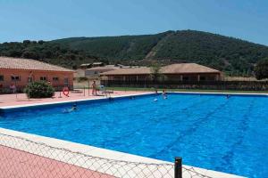 ein großer Pool mit Menschen im Wasser in der Unterkunft Kampaoh Cabañeros in Navas de Estena