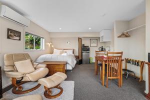 um quarto com uma cama, uma mesa e cadeiras em Gatehouse on the Bay - Christchurch Holiday Unit em Christchurch