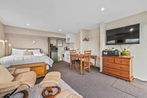 um quarto com uma cama e uma sala de estar em Gatehouse on the Bay - Christchurch Holiday Unit em Christchurch