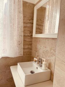bagno con lavandino bianco e specchio di Meraki a Porto SantʼElpidio