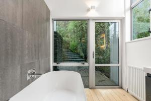 a bedroom with a bed and a large window at A Stunning Stay - Queenstown Holiday Home in Queenstown