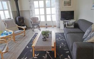 a living room with a couch and a table at Stunning Home In Flekkefjord With House Sea View in Flekkefjord