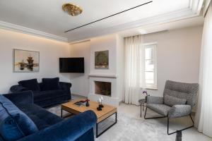 a living room with two blue couches and a fireplace at New York Luxury Suites in Corfu Town