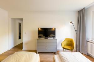 1 dormitorio con 1 cama, vestidor y silla amarilla en Glück Auf Appartements Am Stadtpark Duisburg, en Duisburg