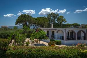 a white house with trees and bushes at Filios Villa in Zakynthos