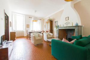 - un salon avec un canapé vert et une cheminée dans l'établissement Albergo diffuso "Centoborghi", à Fivizzano