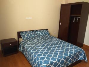 um quarto com uma cama com um edredão azul em Queen M Palace em Addis Ababa