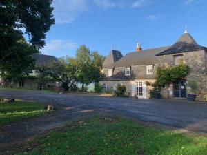 une vieille maison avec une route devant elle dans l'établissement Château de Termes, à Martel