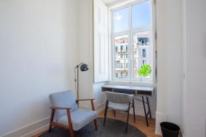 a room with a desk and two chairs and a window at Lisbon Check-In Guesthouse in Lisbon