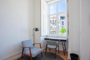 Zimmer mit einem Schreibtisch, 2 Stühlen und einem Fenster in der Unterkunft Lisbon Check-In Guesthouse in Lissabon