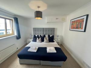 a bedroom with a blue and white bed and a window at Casa Fresa - City Quay Apartment in Dundee