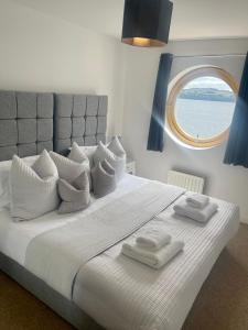 um quarto com uma grande cama branca e uma janela em Casa Fresa - City Quay Apartment em Dundee