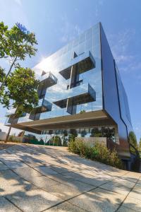 a glass building with the sun shining on it at Suryaa Hotel Pinhais, Curio Collection by Hilton in Pinhais