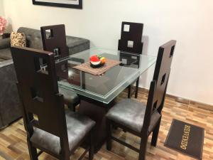 a glass table with chairs and a bowl of fruit on it at Piso 3-Apartment near to Cali airport in Palmira