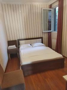 a white bed sitting in a bedroom next to a window at Old Capital in Mtskheta