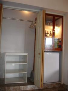 Habitación con armario con puerta y nevera. en Swiss Chalet with Private Kitchen near Lima en Canta
