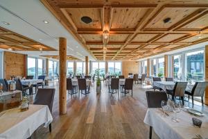 ein Esszimmer mit Tischen, Stühlen und Fenstern in der Unterkunft Hotel Landgasthof Eischen in Appenzell