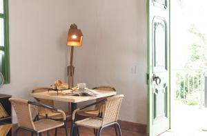uma mesa com cadeiras e um candeeiro num quarto em La Liebre bed and breakfast em El Retiro