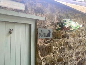 a sign that says the barn with a rabbit next to a door at Duneden Belle Glamping in Randalstown