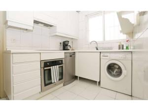 Madrid Views Apartment في مدريد: مطبخ أبيض مع غسالة ملابس وغسالة صحون