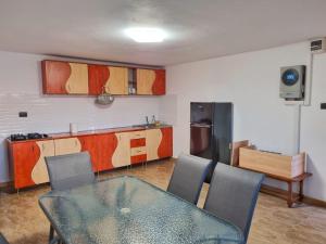 a kitchen with a table and chairs in a room at Cabana Vărad Coronini in Moldova Veche