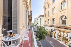 un balcone con tavolo e sedie su una strada della città di Résidence Topaze - Central - Luxurious - 50m Croisette Palais - LRA CANNES a Cannes