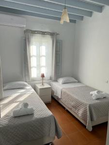 a bedroom with two beds and a window at Patmos Garden in Skala