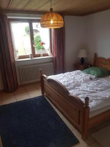 Un dormitorio con una cama grande y una ventana en Ferienwohnung im kuhlen Allgäu, en Missen-Wilhams