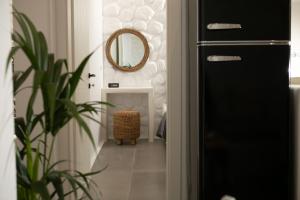 a hallway with a black door and a mirror at Kamvas Deluxe Apartments in Naxos Chora