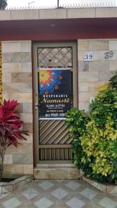 Una puerta de un edificio con un cartel en ella en Hospedaria Namastê, en Peruíbe