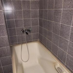 a bath tub with a shower in a bathroom at хотел Кристиан in Sozopol