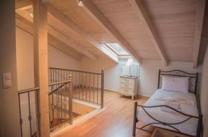 a attic bedroom with a bed and a staircase at House Vraсhos-Loutsa in Vrachos