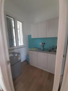 uma cozinha com armários brancos e um lavatório em Molto Benissimo em Otranto