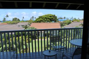 Un balcón con sillas y mesas y vistas al océano. en Kiahuna Plantation 96, Poipu Beach, Athletic Club Membership, Part Ocean View, en Koloa