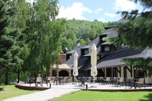 eine Gruppe von Tischen und Stühlen vor einem Haus in der Unterkunft Hotel Junior in Kopaonik