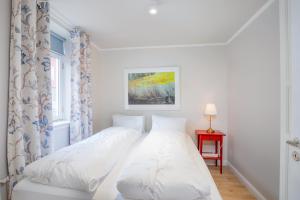 białe łóżko w białej sypialni z oknem w obiekcie Live as Locals Apartments w Reykjavík