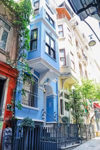 una casa azul en una calle frente a los edificios en BLUE PERA HOUSE en Estambul